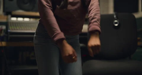 R&amp;B dancer grooving in front of professional mixing board in studio. Medium shot Stock Footage 199457786