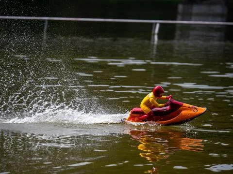 RC controlled jet ski model on lake. Active summer vacation for school child. Stock Photos