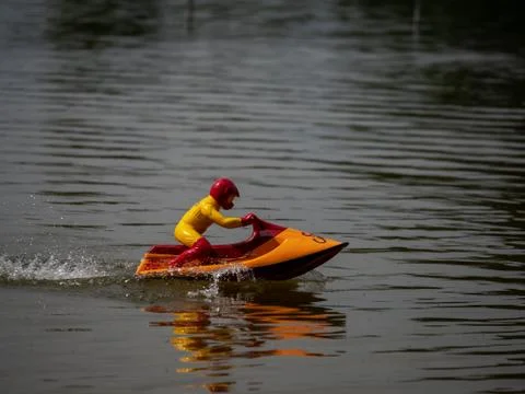 RC controlled jet ski model on lake. Active summer vacation for school child. Stock Photos