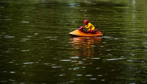 RC controlled jet ski model on lake. Active summer vacation for school child. Stock Photos