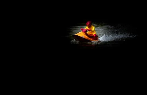 RC controlled jet ski model on lake on black background. Active summer vacati Stock Photos