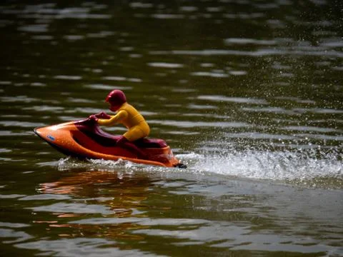 RC controlled jet ski model on lake. Active summer vacation for school child. Stock Photos