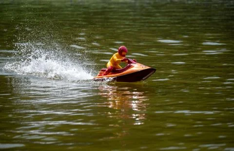 RC controlled jet ski model on lake. Active summer vacation for school child. Stock Photos