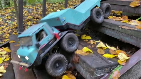 RC flatbed towing truck going downstairs in autumn park. Stock Footage 207406527