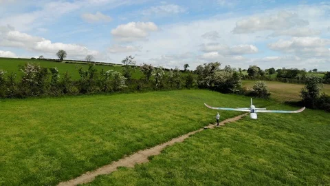 Rc pilot flys plane over sunny fields Stock Footage 108504939