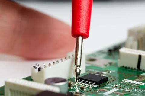 ?rcuit board with electronic components and a multimeter with test probes. Foto stock
