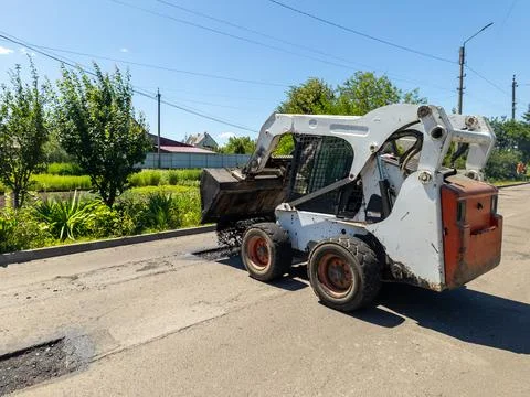 A re -control loader drops asphalt on the side of the road Stock Photos