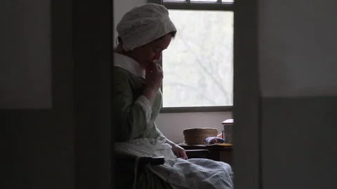 Re-enactor sewing in a Colonial, 18th Century New England cottage - Portrayal Stock Footage 170530387