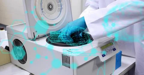 Reaching blue-nitrile-gloved hand in white lab coat into open centrifuge on lab Stock Photos