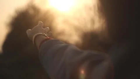 Reaching Hand Towards Glowing Sun in Golden Hour Stock Footage 346029716