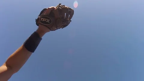 Reaching to make catch of baseball in slow motion Stock Footage 80357838