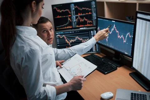 Reaching point of these two employees. Team of stockbrokers are having a conv Stock-Fotos