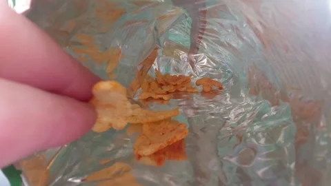 Reaching for potato chips inside a foil snack bag, crunchy snacks close up Stock Footage 334836140