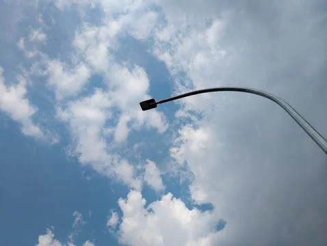 Reaching for the Sky: A Curved Lamp Post and Cloudy Day Stock Photos