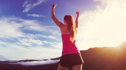 Reaching The Top. Happy successful fitness woman raising arms to the sky at s Stock Footage