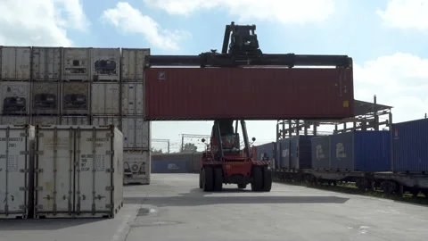 Reachstacker carries a container in front of a container logistics terminal. Stock Footage 148464584