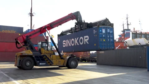 Reachstacker holds a large container for loading onto a truck Stock Footage 149467923