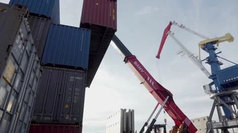 A reachstacker lifts a large container and places it on top of another container Stock Footage 147645227