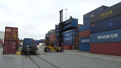 Reachstacker removes container from container for loading onto truck Stock Footage 145702632