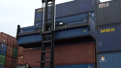 The reachstacker takes a large container from the container yard  Stock Footage 145702648