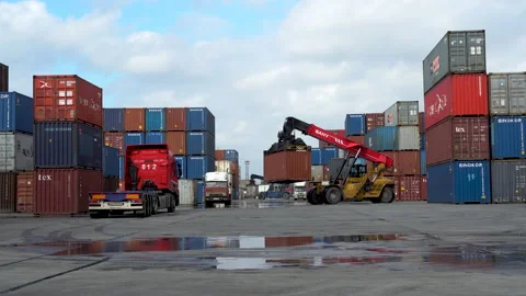 A reachstacker transports a container amid loading and unloading operations. Stock Footage 148691950
