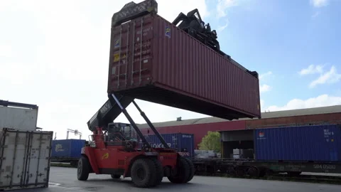 A reachstacker transports a large container through  Stock Footage 148466299