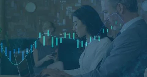 Reacting to animated chart overlay, pair in blouse and suit jacket typing on Stock Photos