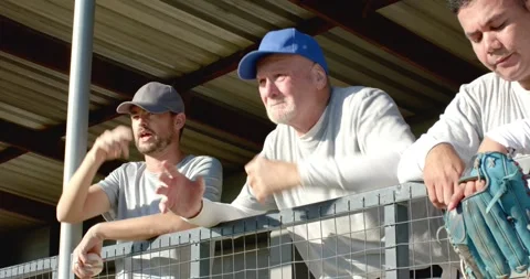 Reacting to game error, diverse baseball coach and player slumping on dugout Stock Footage 344534609