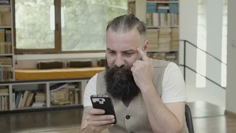 Reaction of a young man with beard trying to understand and thinking of what  Stock Footage 90555993