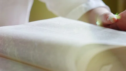 Read book. Female hand leafing through the pages of a big book. Sun flare. Close Stock Footage 126624172