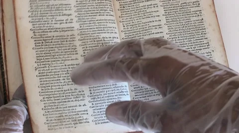 Read a book with gloves - 4k Stock Footage 53468479