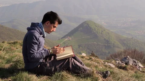 Read a book in solitude on the mountain top Stock Footage 49781931