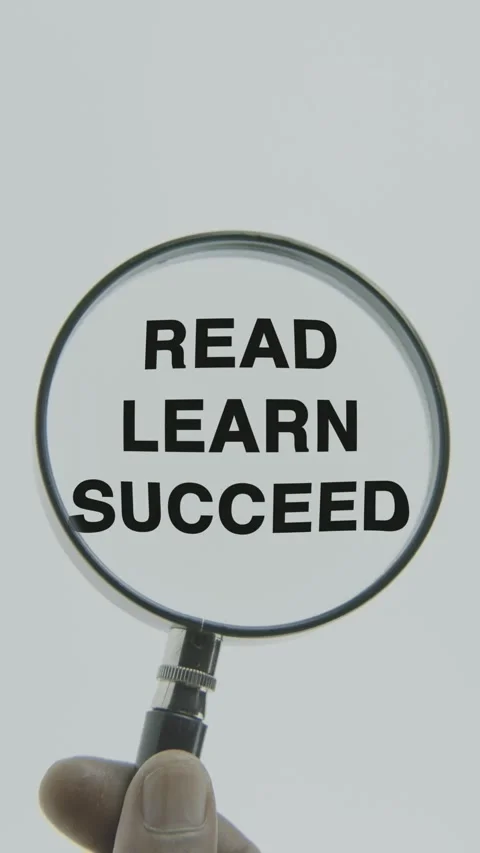 Read Learn Succeed text or word highlighted by a magnifying glass in a hand Stock Footage 303508098