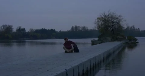 Reader in Evening on Concrete Pier River Small Stony Island Overgrown With Stock Footage 60438570