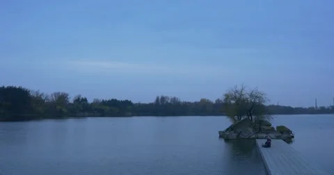 Reader Man With Book on Concrete Pier on River Small Island Overgrown With Stock Footage 60406527