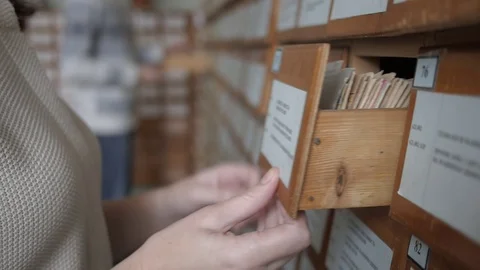 Reader searching the book in the card index of the library catalog Stock Footage 71070376