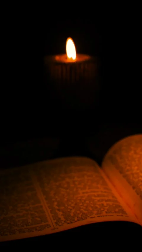 Reading ancient scriptures by candlelight in a quiet, dark room Stock Footage 320751588