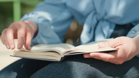 Reading and annotating outside, person engaged in studying outdoors with notes Stock Footage 326487639
