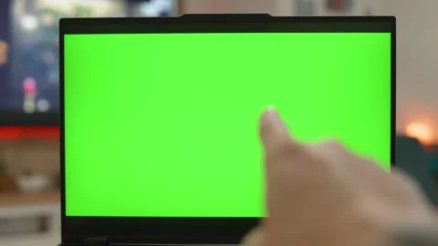 Reading and Pointing Laptop with Blank Green Screen in a Bright Workspace Stock Footage 302344291