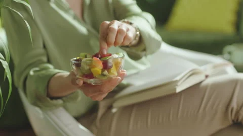 Reading and Snacking with Fresh Fruit Salad at Home Stock Footage 335170136