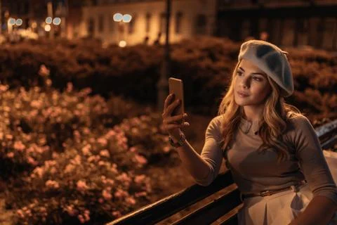 Reading an article while waiting for her friend Stock Photos