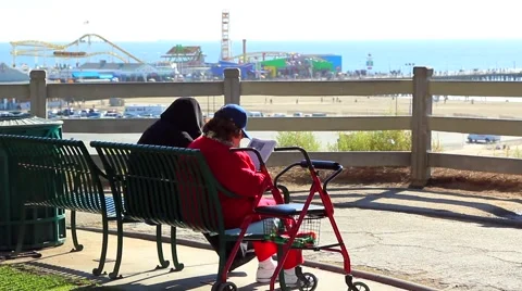 READING ON BENCH BY OCEAN Video stock 948203