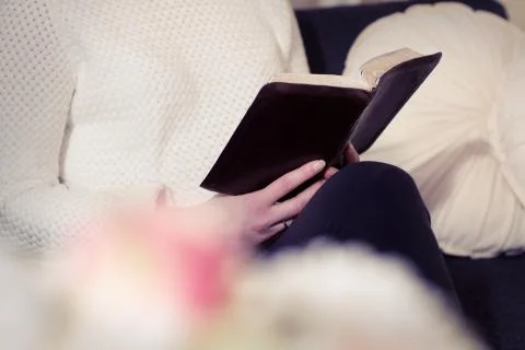 Reading the bible alone in a sofa Stock Photos