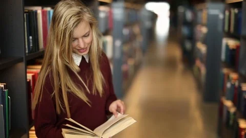 Reading blond in library Stock Footage 80958454