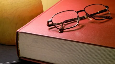 Reading: book and glasses under lamp Stock Footage 8921183