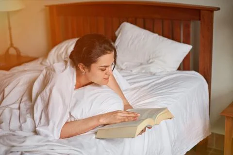 Reading book in bed theme Stock Photos