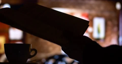 Reading book in a cafe while drinking coffee tea Stock Footage 54074833