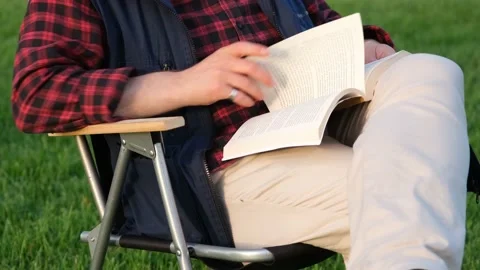 Reading book on camp chair Stock Footage 168651685