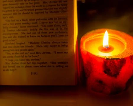 Reading a book by candlelight Stock Photos