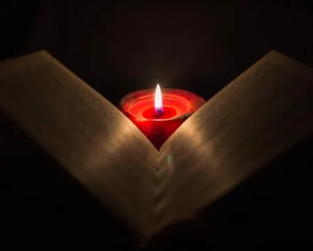 Reading a book by candlelight Stock Photos